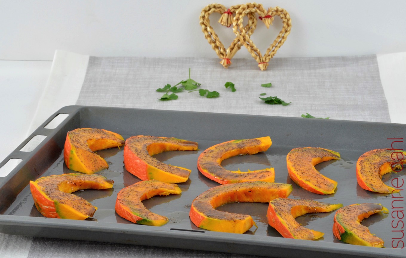 Kürbisschnitze mit Gewürzen bestrichen auf dem Blech